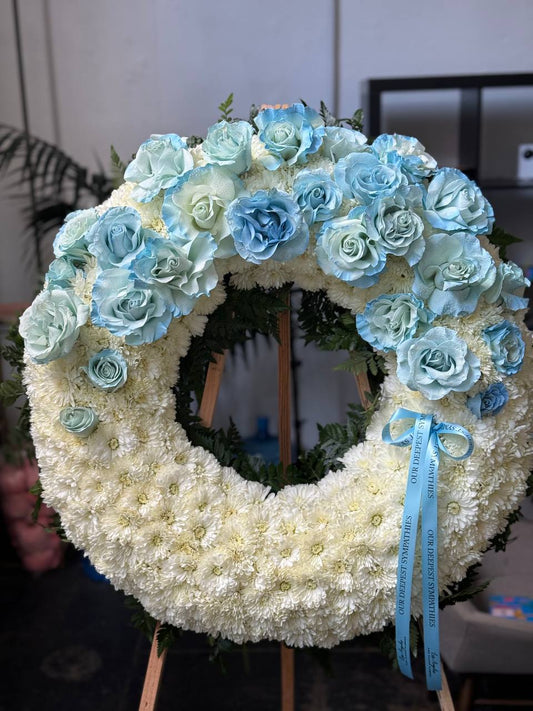 Circular spray bouquet of blue roses and hydrangeas with gold accents, symbolizing unity and serenity