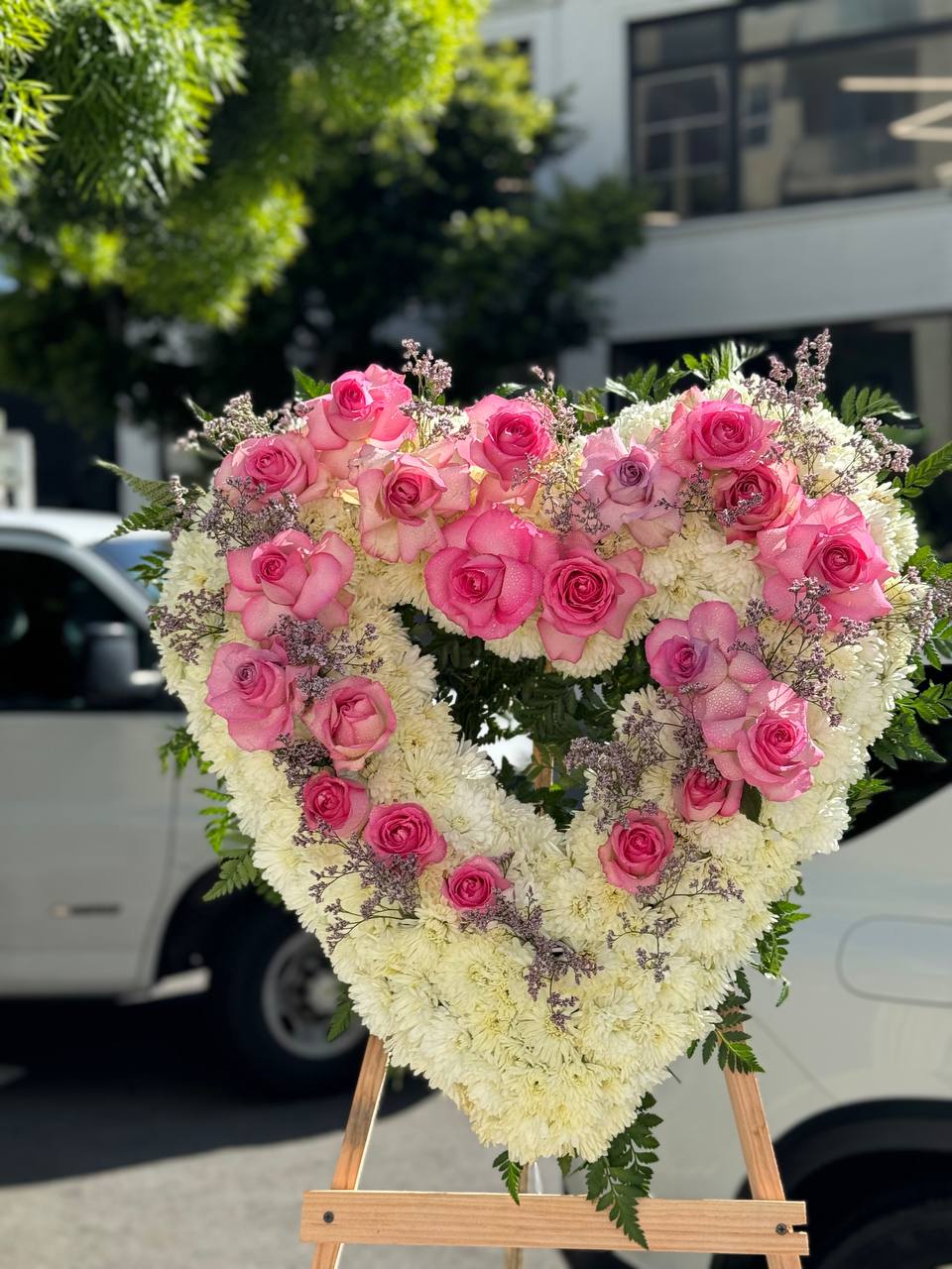 Artisan-crafted Sympathy Heart Pink arrangement featuring lush blooms and ivory accents