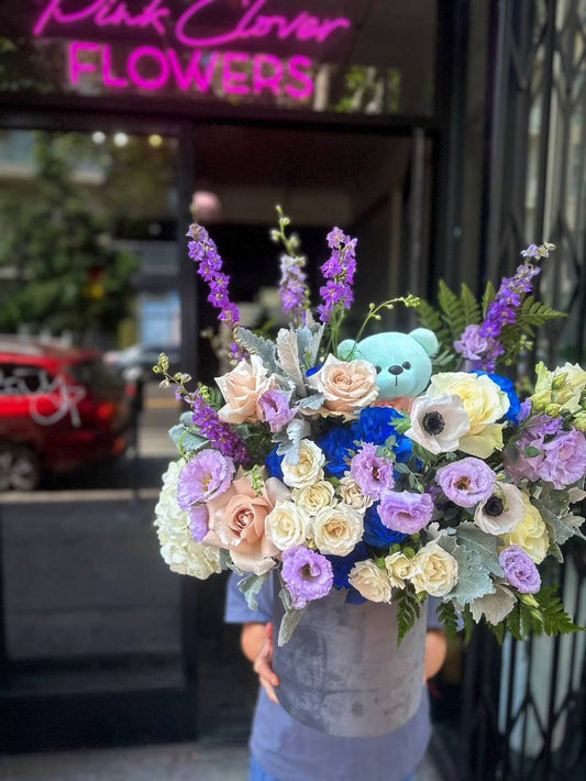 Close-up of Royal Blue Roses and Eustoma in a hand-tied bouquet, accented with Delphinium for a touch of whimsy.