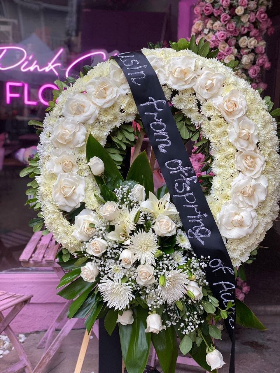 Serene white and green floral spray arrangement styled in a timeless circular design for remembrance occasions