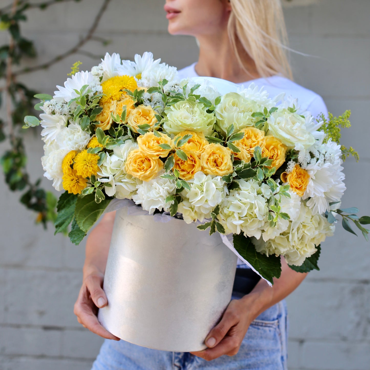 Zara's handmade floral gift features fresh yellow roses and white flowers in a gift box for a joyful and sophisticated look.