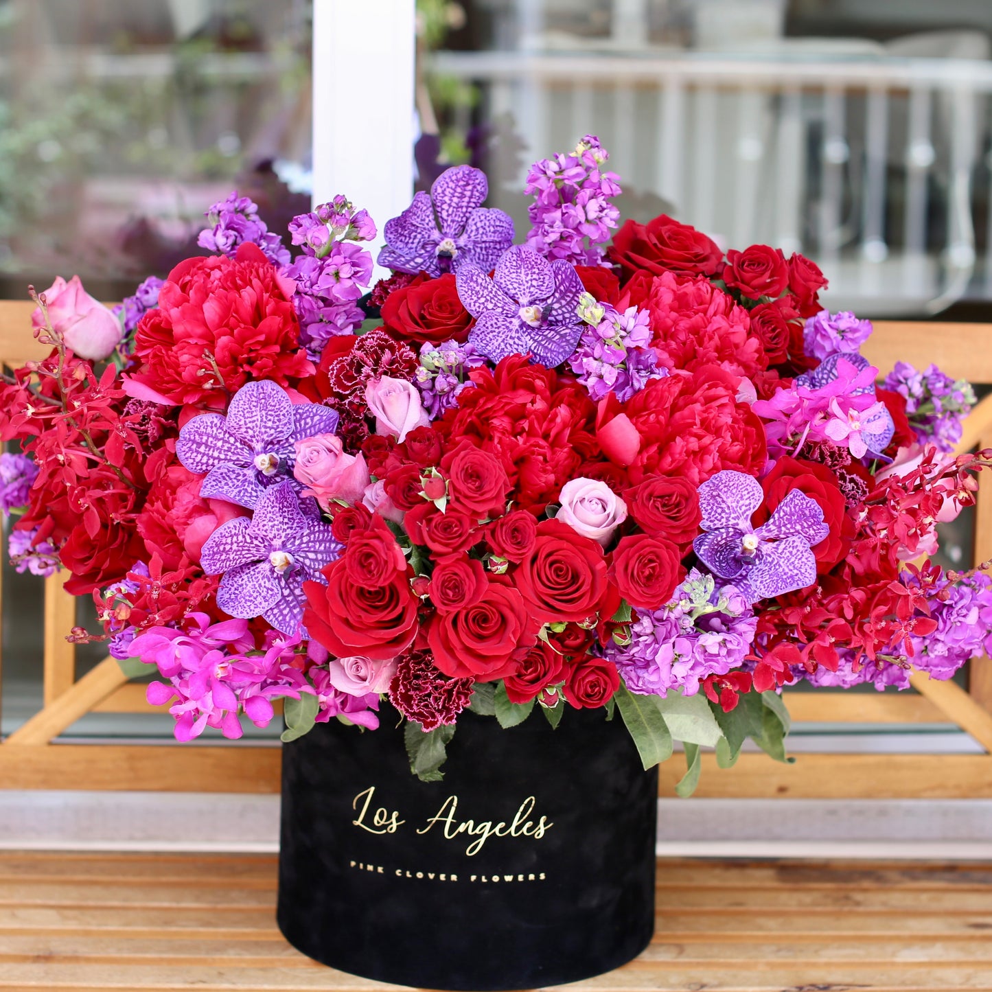 Stunning close-up of red roses, peonies and orchids bouquet, showcasing fresh blooms and artistic floral craftsmanship