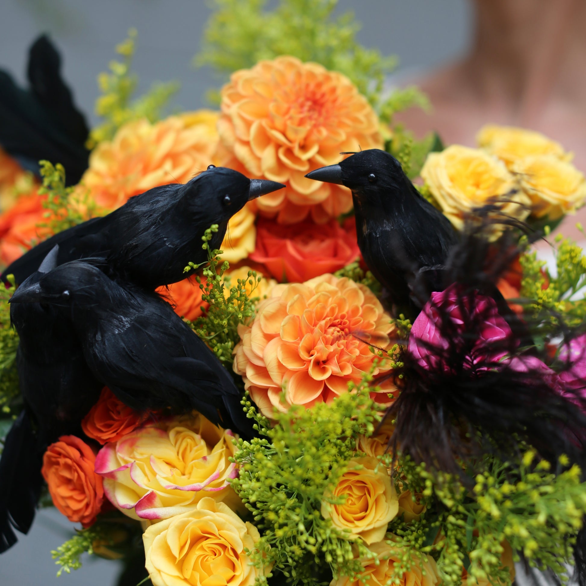 Festive fall floral arrangement styled with warm-toned roses and unique black crow accents, perfect for luxury seasonal décor