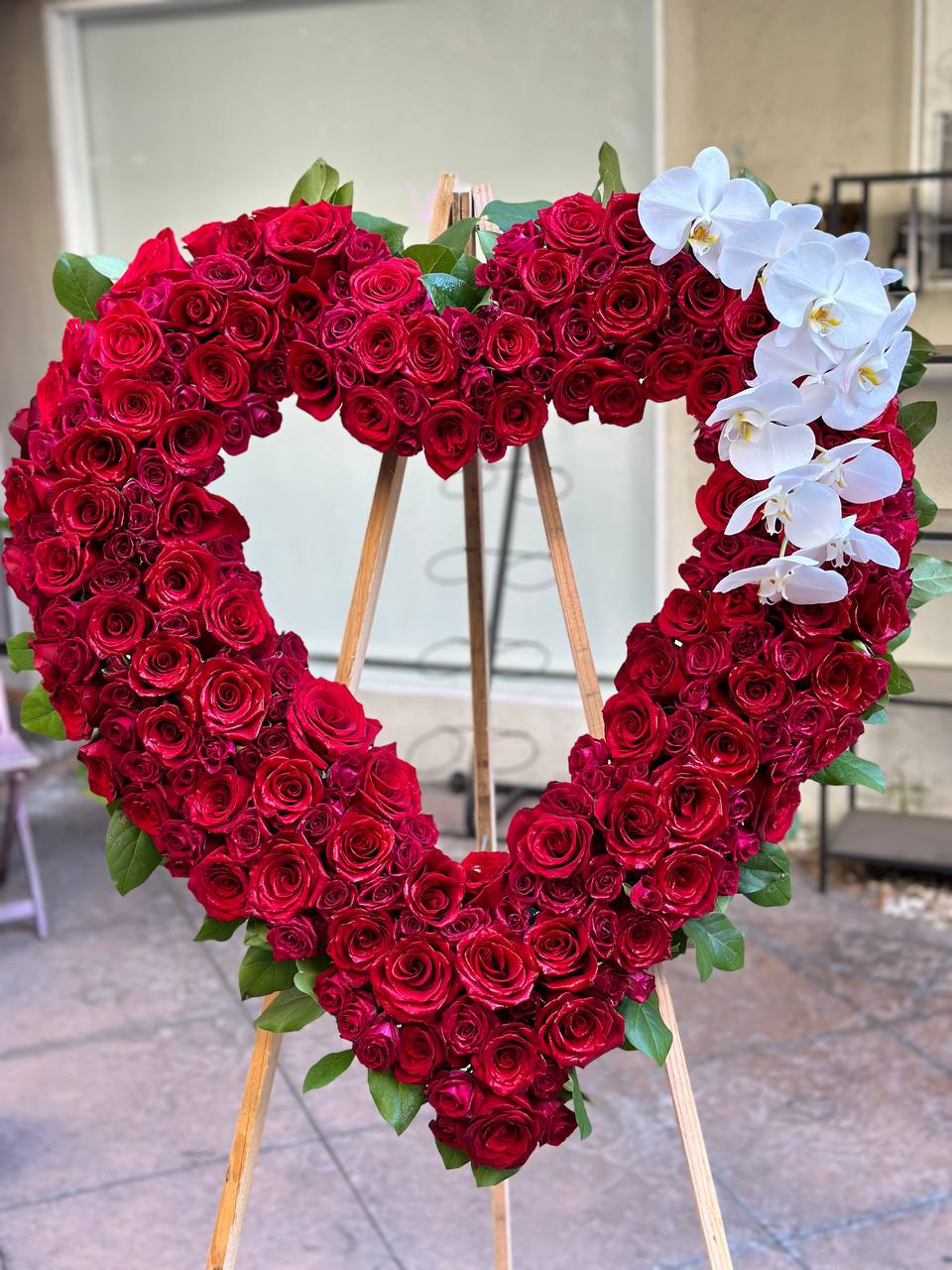 Premium red floral heart stand with roses and orchids, styled for elegant memorials and special occasions in Los Angeles