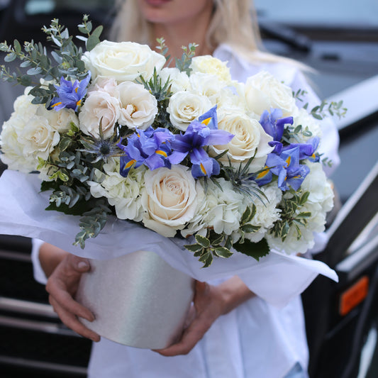 Elegant floral arrangement featuring white roses, irises and mixed flowers in a decorative keepsake box, styled for premium gifting