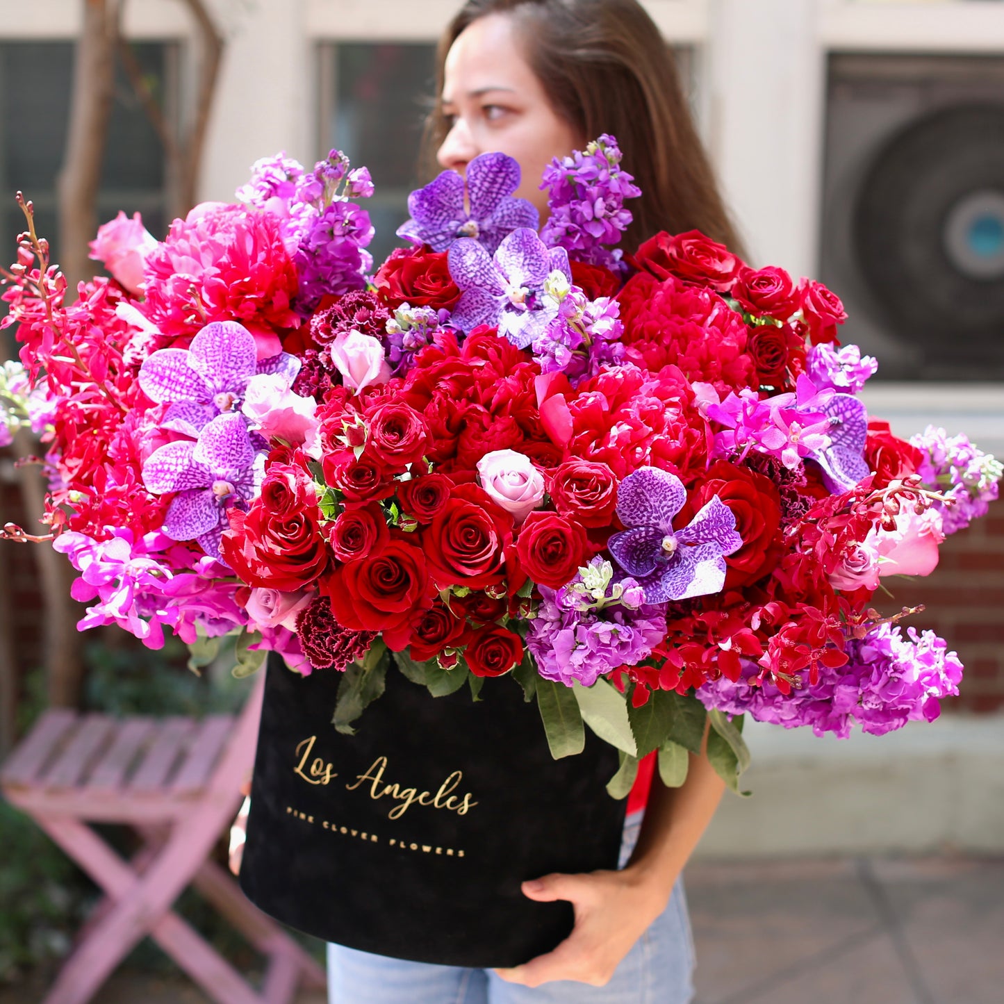 Elegant red roses and orchids floral design, beautifully styled in a large decorative box for luxury gifting and special celebrations
