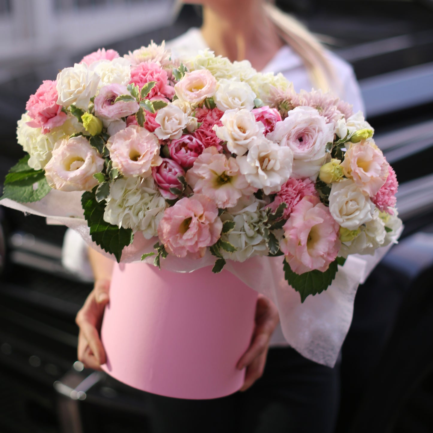 Soft pink and white floral arrangement featuring ranunculus, lisianthus and hydrangeas in a decorative pink keepsake box