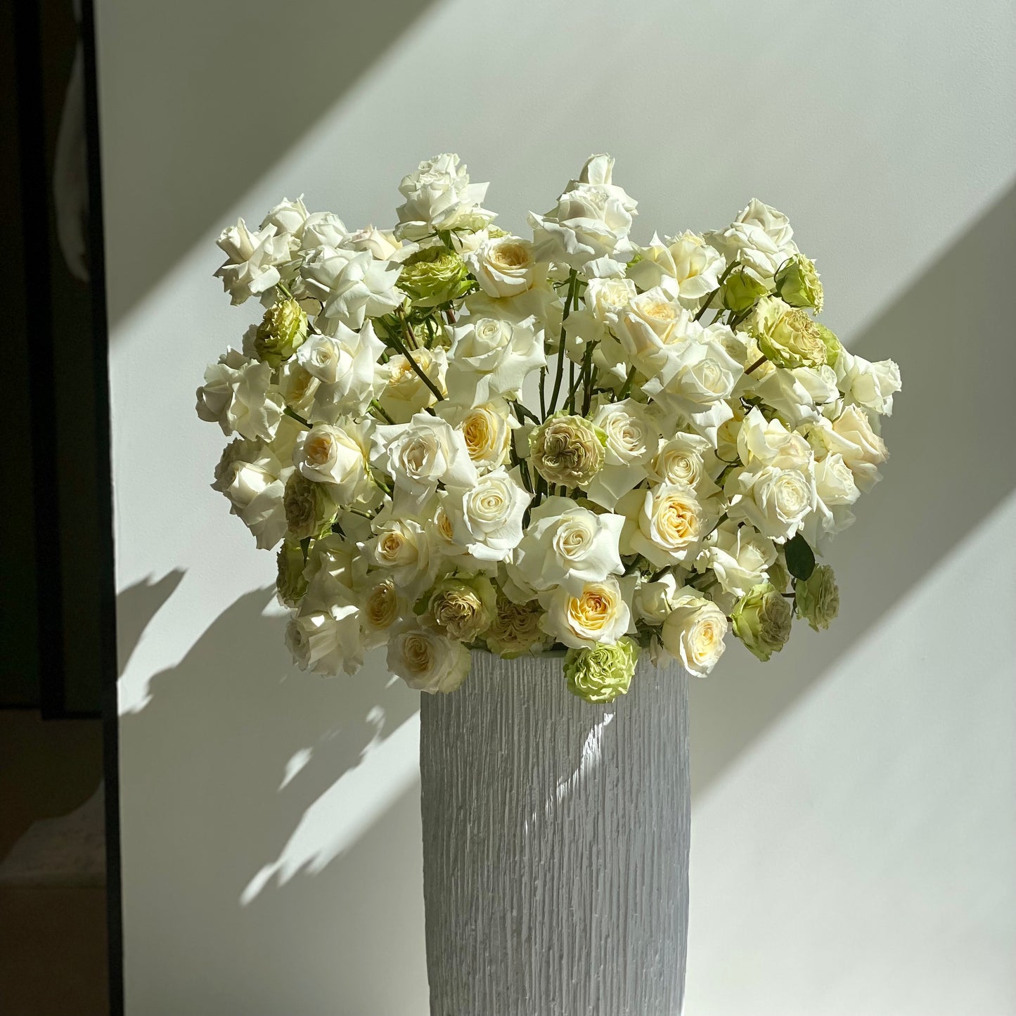Elegant white and beige rose arrangement styled in a minimalist high vase design, ideal for modern home décor and premium delivery