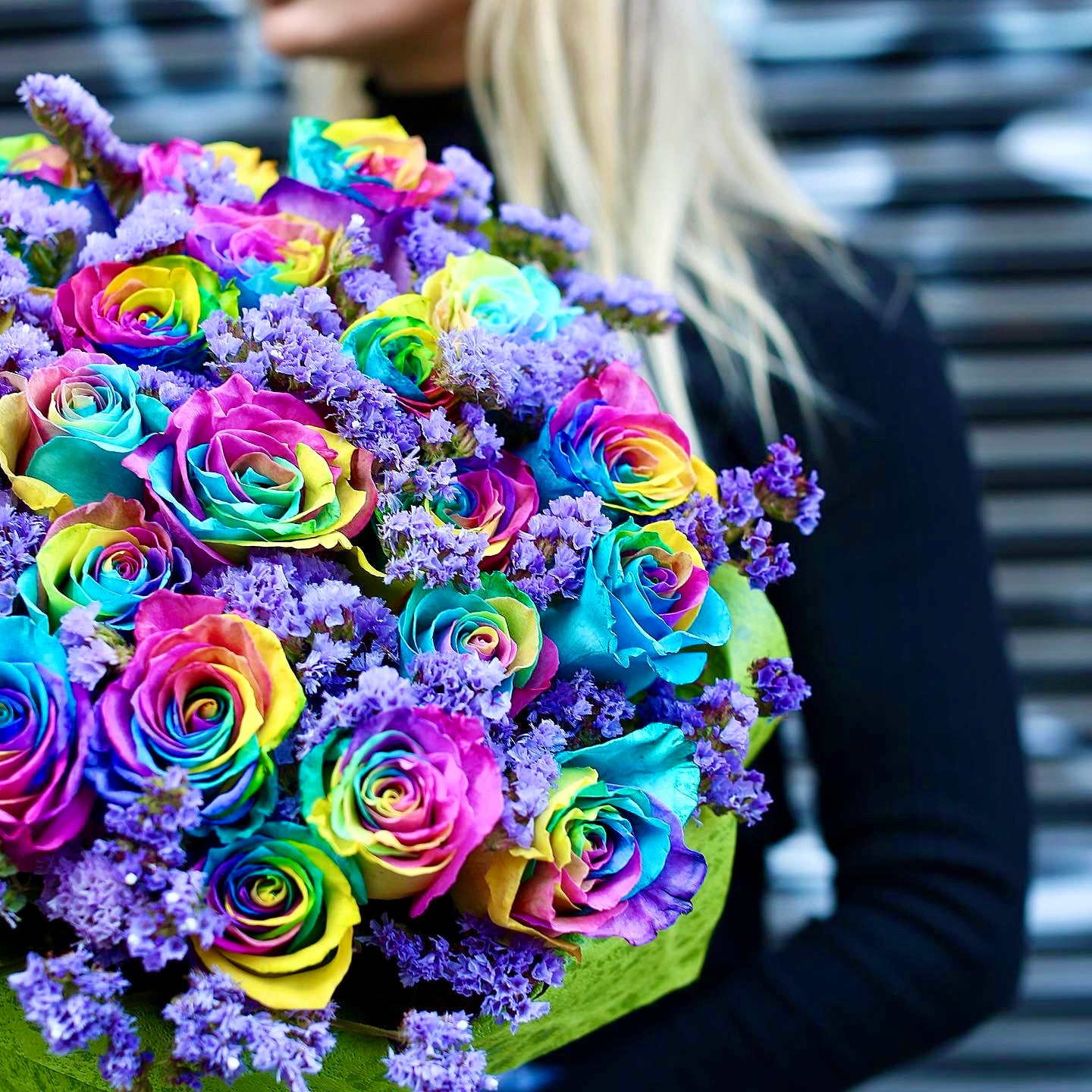 Colorful floral arrangement showcasing rainbow-hued roses and fresh blooms, styled for cheerful delivery and premium presentation
