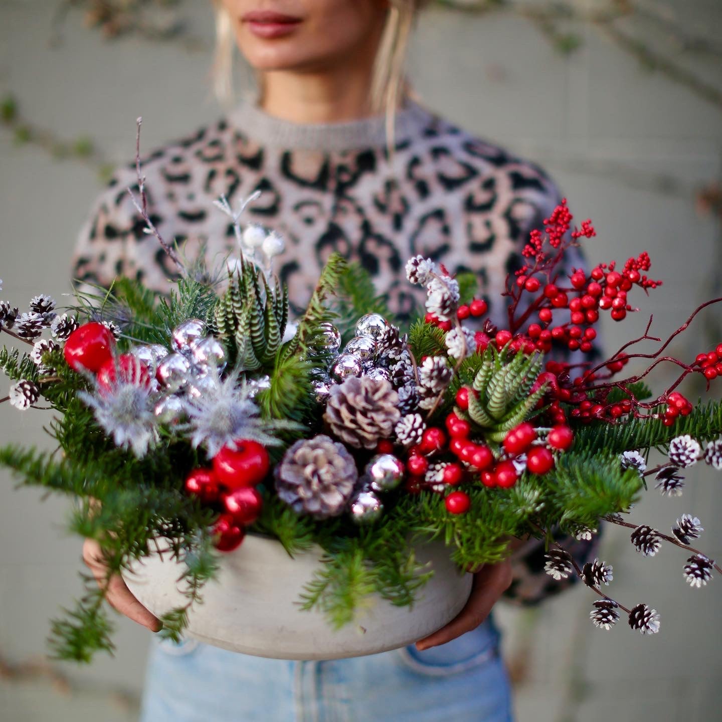 Vibrant Christmas bouquet with red berries, pinecones and frosted foliage, styled for festive holiday gifting