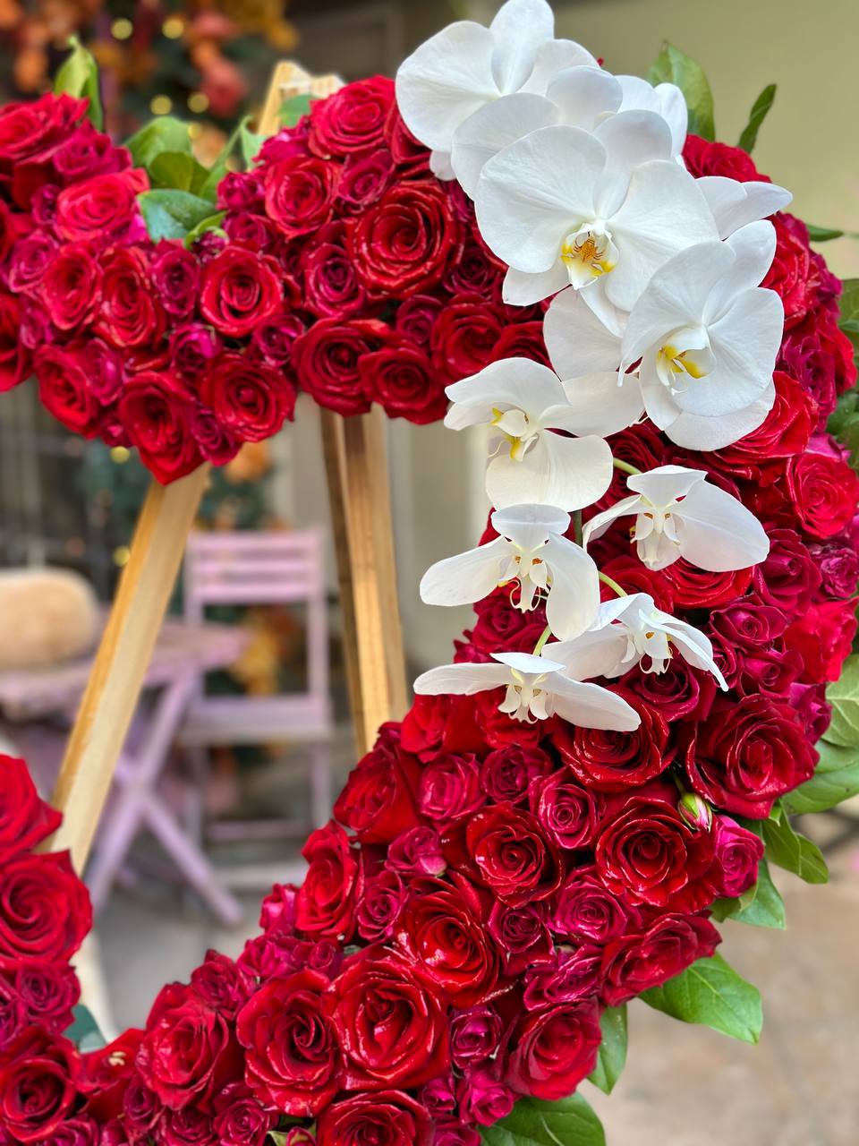 Handcrafted Heart Stand Red bouquet showcasing vibrant red roses and orchids in a meaningful heart-shaped presentation