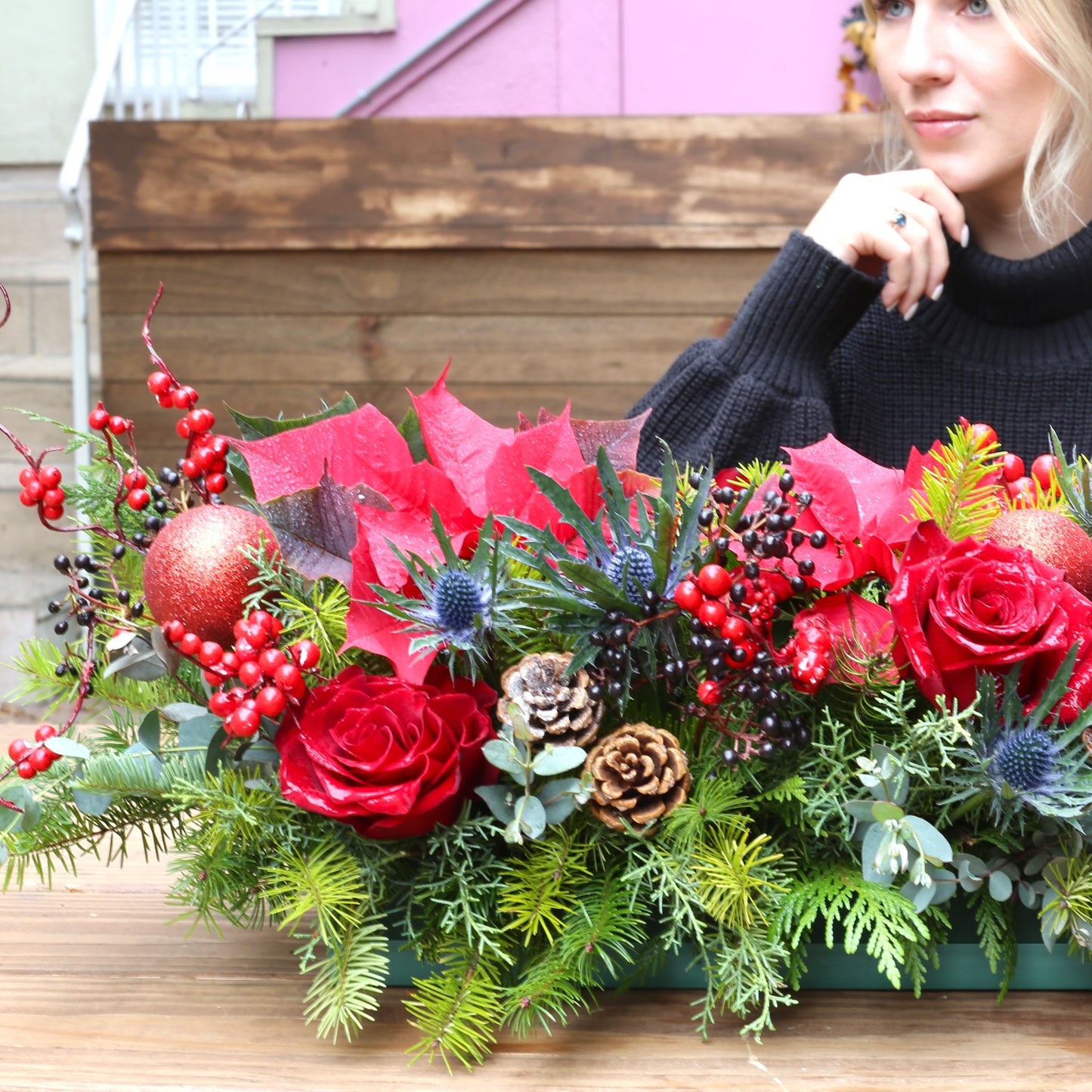 Festive Christmas centerpiece showcasing fresh white flowers and seasonal greenery in a celebratory, curated design