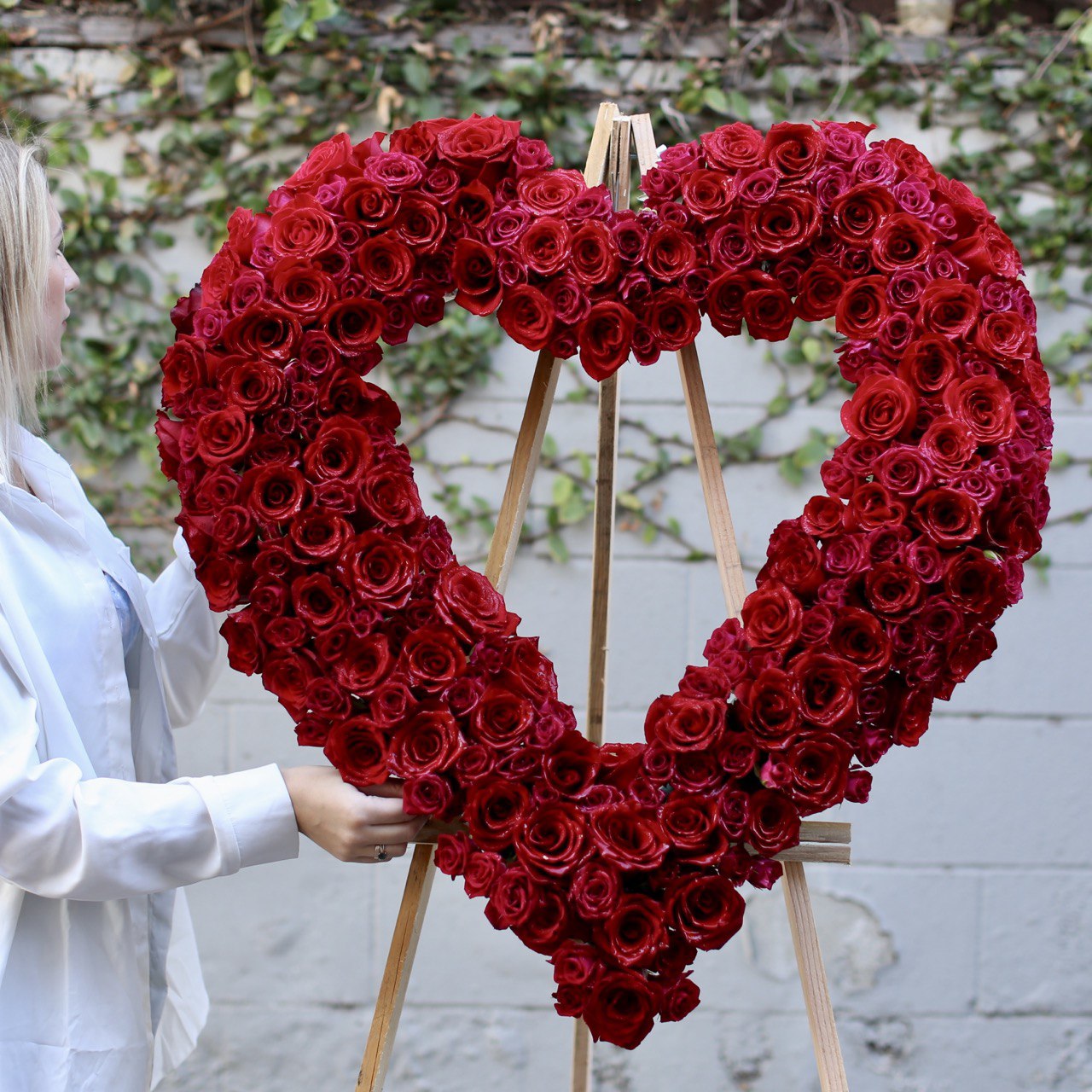 Heartfelt Heart Stand Red arrangement featuring red roses and orchids in a standing heart shape, ideal for remembrance and luxury floral delivery