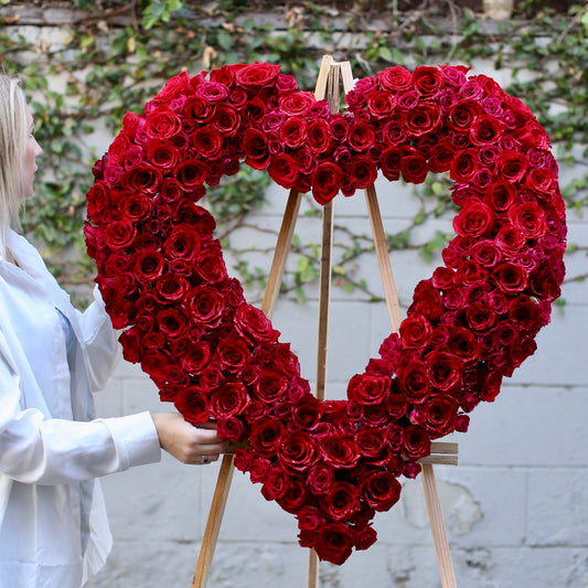 Heartfelt Heart Stand Red arrangement featuring red roses and orchids in a standing heart shape, ideal for remembrance and luxury floral delivery